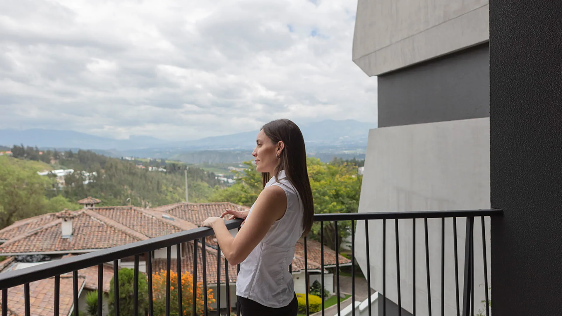 Una mujer viendo el panorama desde el balcón